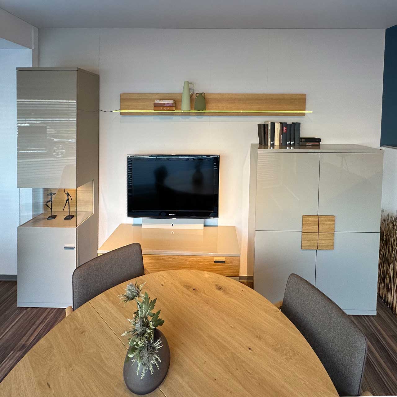 Rietberger - Wohnwand Lodano vierteilig Wohnwand im Überblick - links Vitrine, daneben Lowboard mit Fernseher und darüber Wandbord mit Beleuchtung. Ganz rechts ein Highboard mit vier Türen.