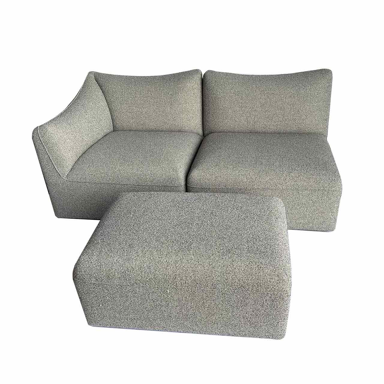 Der Hocker steht vor dem Sofa