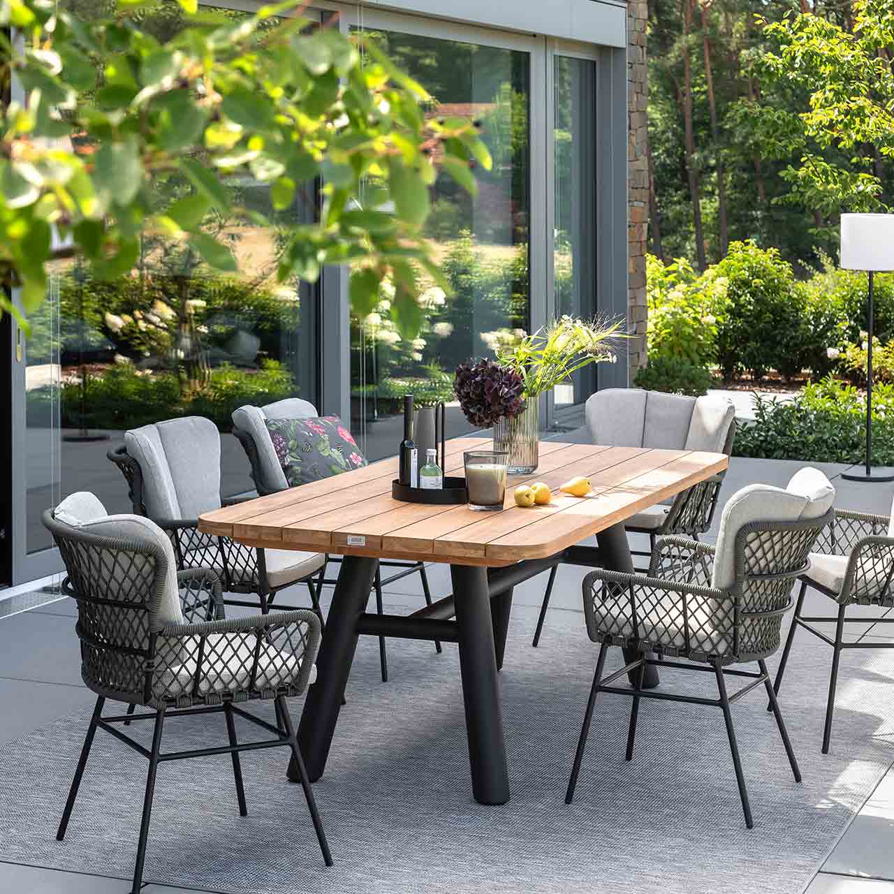 Gartenesstisch Gruppe mit dem modernen rechteckigen Teakholztisch SABA mit swarzen modernen Untergestell, passend dazu der geflecht Stuhl Bennett inklusive Sitzkissen