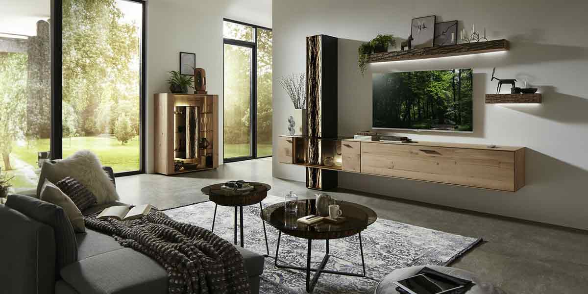 MH_Kategorie_Wohnzimmer_1200x600 Stilvolle Wohnzimmerlandschaft, TV-Board aus Holz, Couchtisches mit dunkler Glasplatte und modernem Sofa in grau.