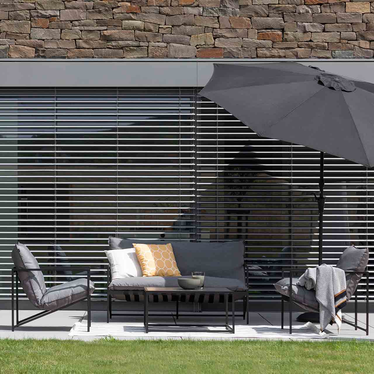 Gartenlounge AMELAND bestehend aus zwei Sessel & 2-er Loung in Grauen wetterbeständigen Sitzkissen und schwarzen filigranenGestell.
