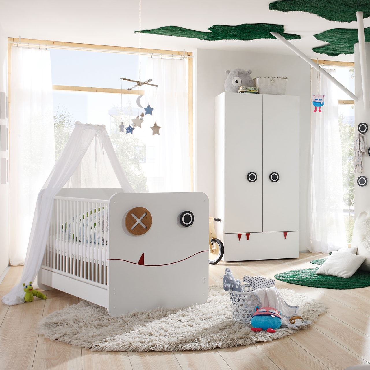 MH_Kategorie_Lagerware_Kachel_Kinderzimmer Ambientebild lichtdurchflutetes Kinderzimmer in Weiß und Holzakzenten. Babybett mit Himmel, Kleiderschrank, Wickelkommode, gemütliche Teppiche und Dekoelemente.