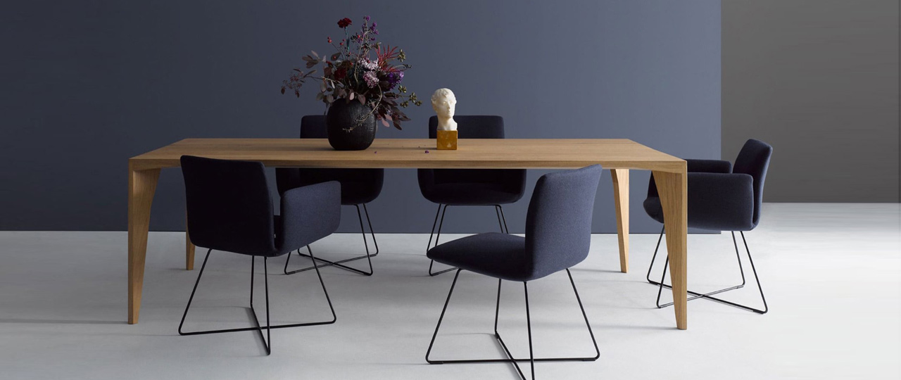 MH_banner_marken_cor Stilvolle moderne Essgruppe der Marke COR. 5 Polsterstühle mit Schlichten Metallfüßen in schwarz gehalten mit rechteckigem Holztisch und dekorativer Vase.