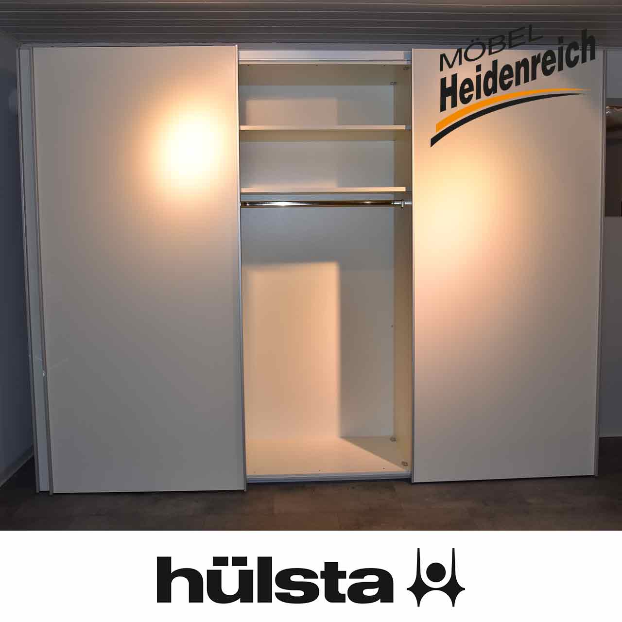 Mittlere Tür ist geöffnet. Blick auf zwei Fächer oben und eine Kleiderstange.