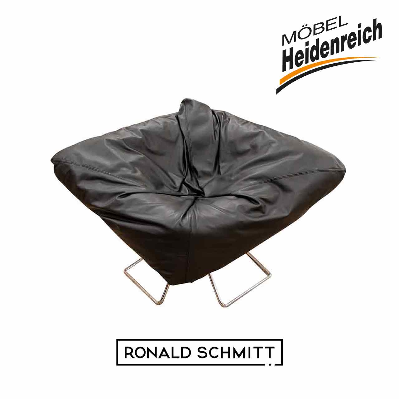 Schwarzer Ledersessel mit rautenförmiger knautschiger Sitzfläche auf Metallkufen.