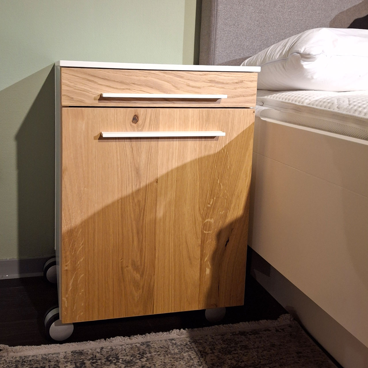 Loddenkemper - Bettanlage mit Konsolen Bettkonsole mit weißen Korpus und Fronten in Balkeneiche. Die Griffe sind weiß.