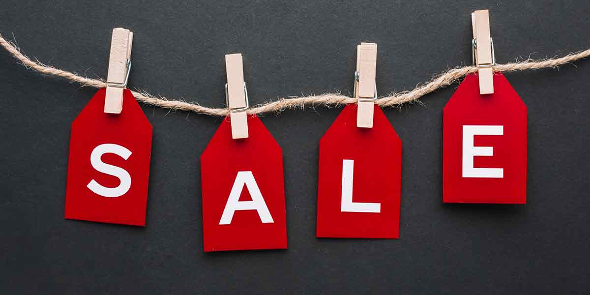 Sale Banner Hier sieht man das Banner der Sale Seite. Eine Schnur an der Wäscheklammern die Karten in Rot mit weißem Buchstaben mit den einzelnen Buchstaben von Sale nebeneinander fixieren.