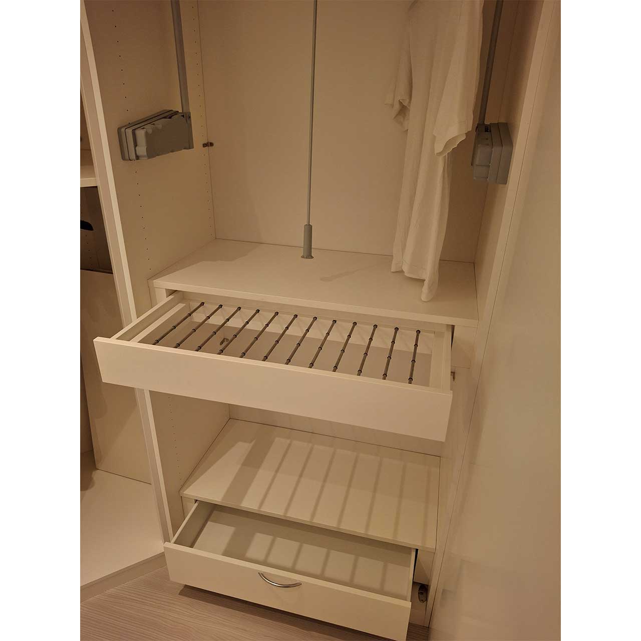 Gleicher Schrank mit aufgezogenem mittleren Fach mit Hängemöglichkeiten und ausgezogener Schublade unten.
