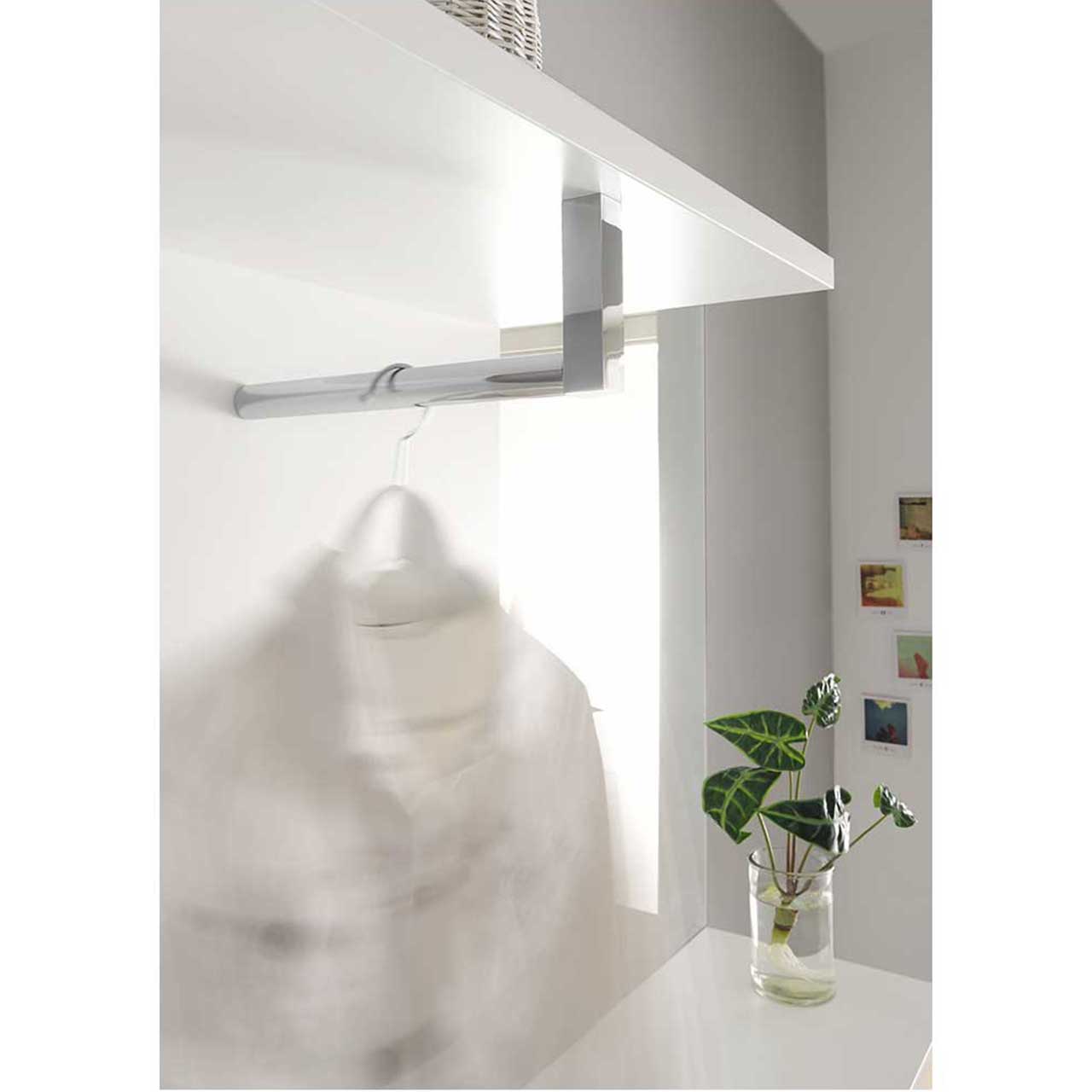 Detailaufnahme der glänzenden Garderobenstange des Garderobenpaneels mit angehängtem Kleiderbügel.