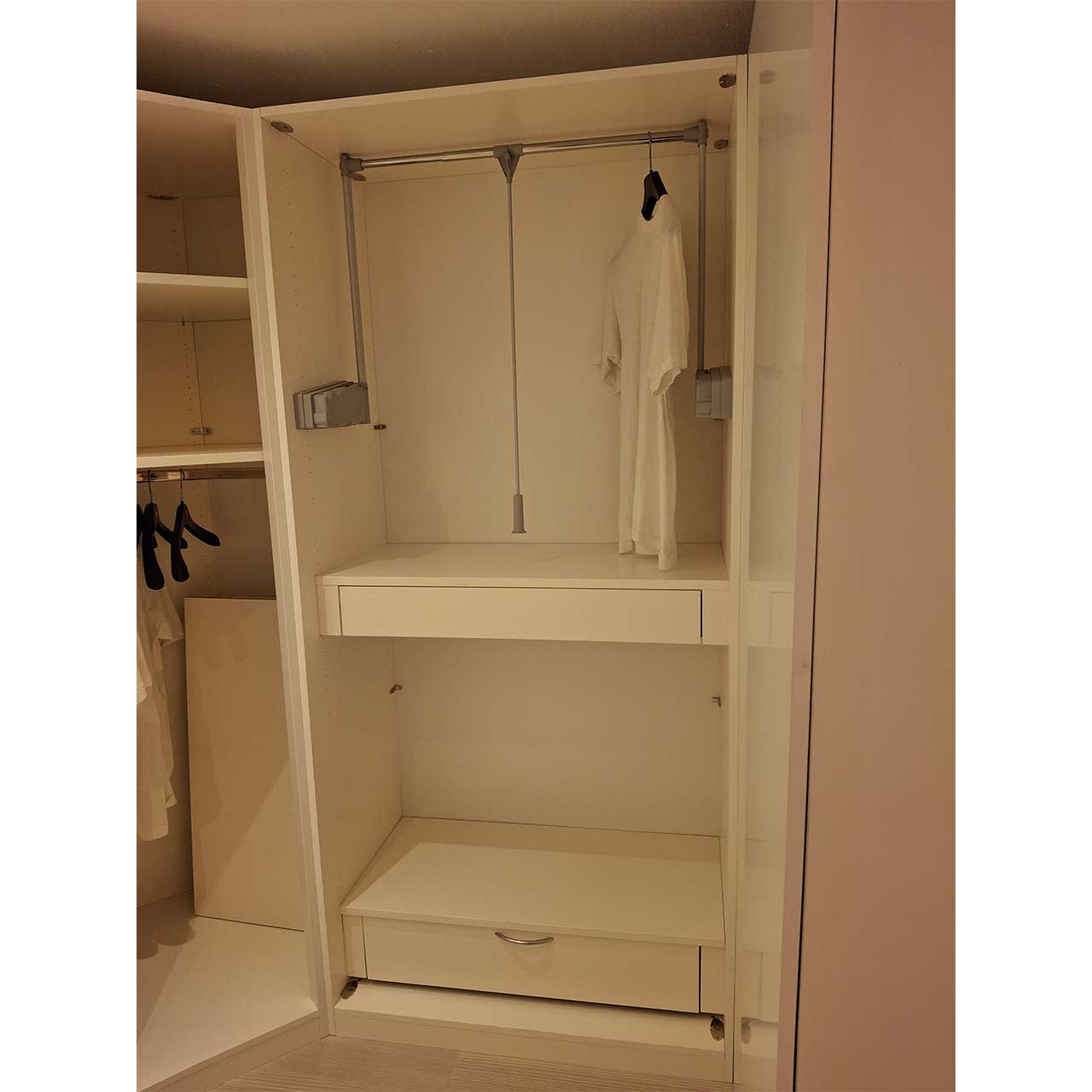 Innen im rechten Schrank befindet sich oben ein Kleiderlift, unten ist ein Fach und ganz unten ein weiteres Fach sichtbar.
