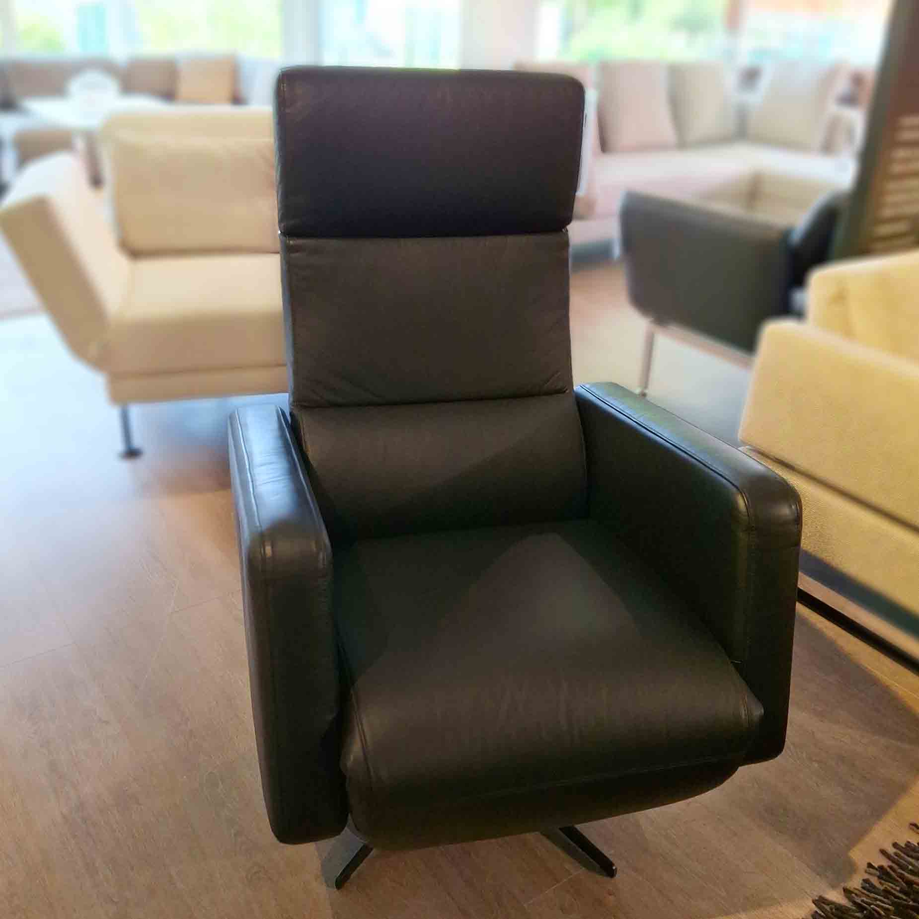 Schwarzer Relaxsessel mit Sternfuß.