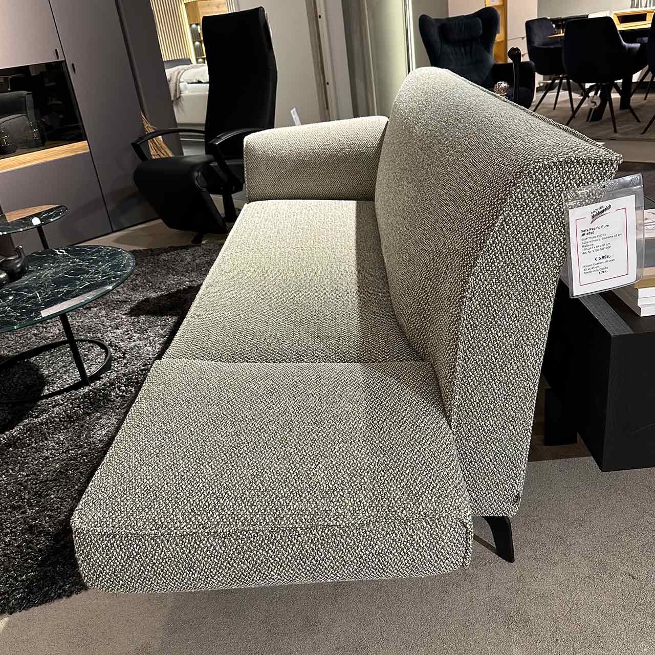 Gleiches Sofa, bei dem auf einer Seite die Armlehne abgeklappt ist auf gleiche Ebene wie die Sitzfläche.