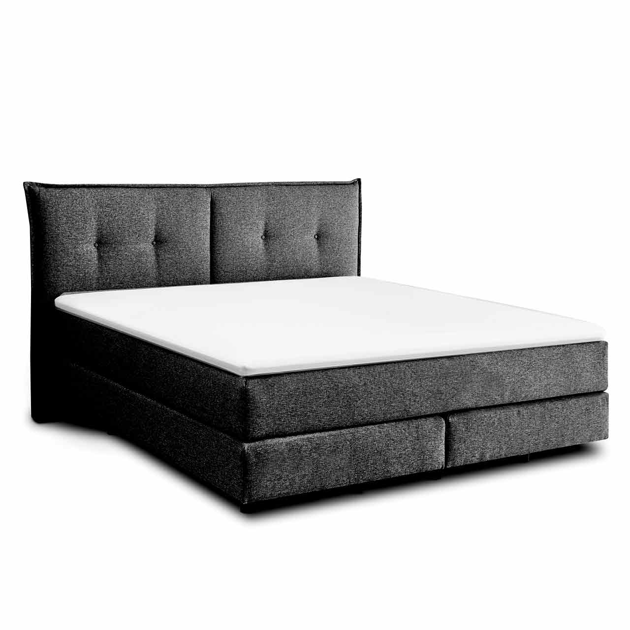 Schwarzes Boxspringbett mit zwei Boxen unten und darüber zwei Matratzen in einer Hülle. Darauf liegt ein weißer Topper. Das Kopfteil in Kissenoptik ist zweigeteilt und hat jeweils zwei Knopf-Einzüge auf jeder Seite.