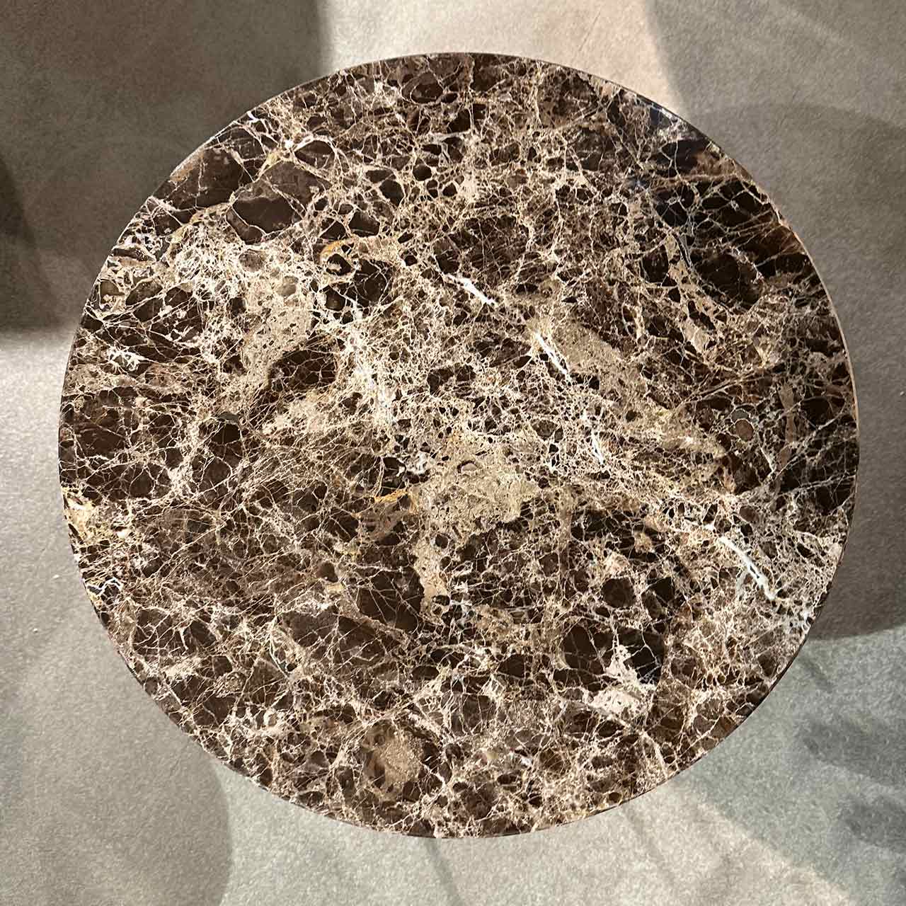 Fotografie von oben, so dass die dunkel-helle Marmorierung der Tischplatte sichtbar ist.