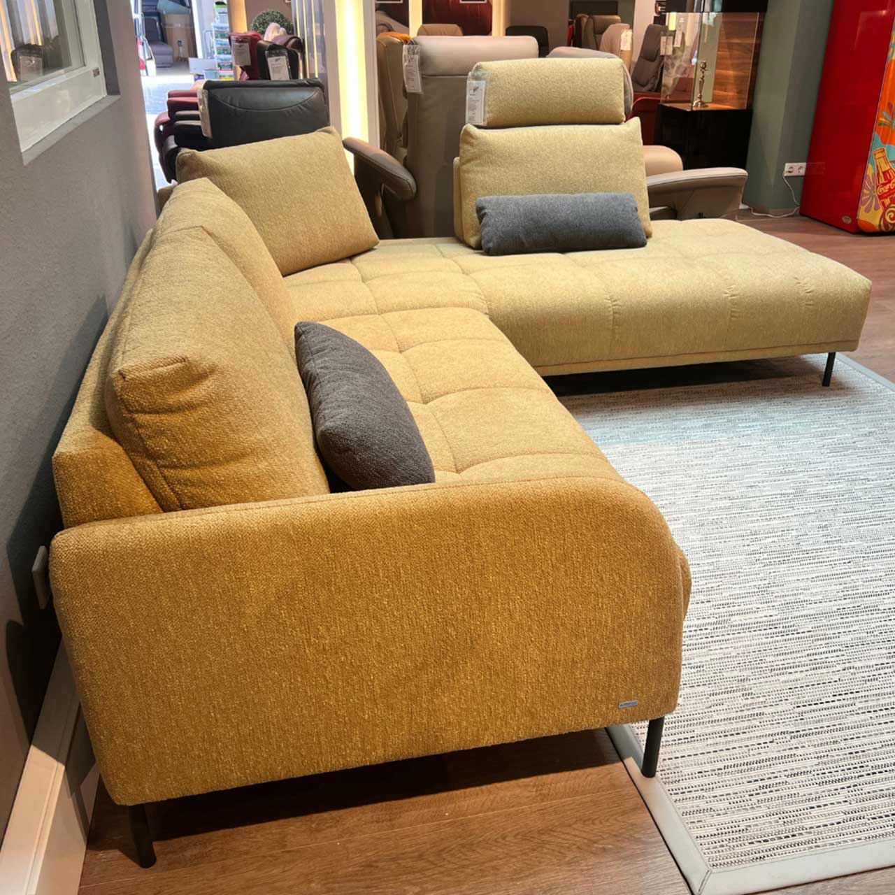Gleiches Sofa von der Seite. Die vorne abgerundete Armlehne ist im Fokus.
