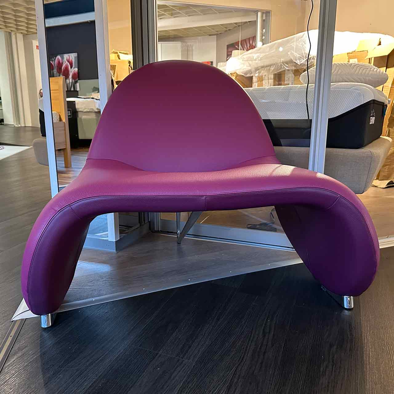 Der Sessel hat eine organische Form, die fast wie ein umgedrehtes U aussieht mit kurzer Rückenlehne.