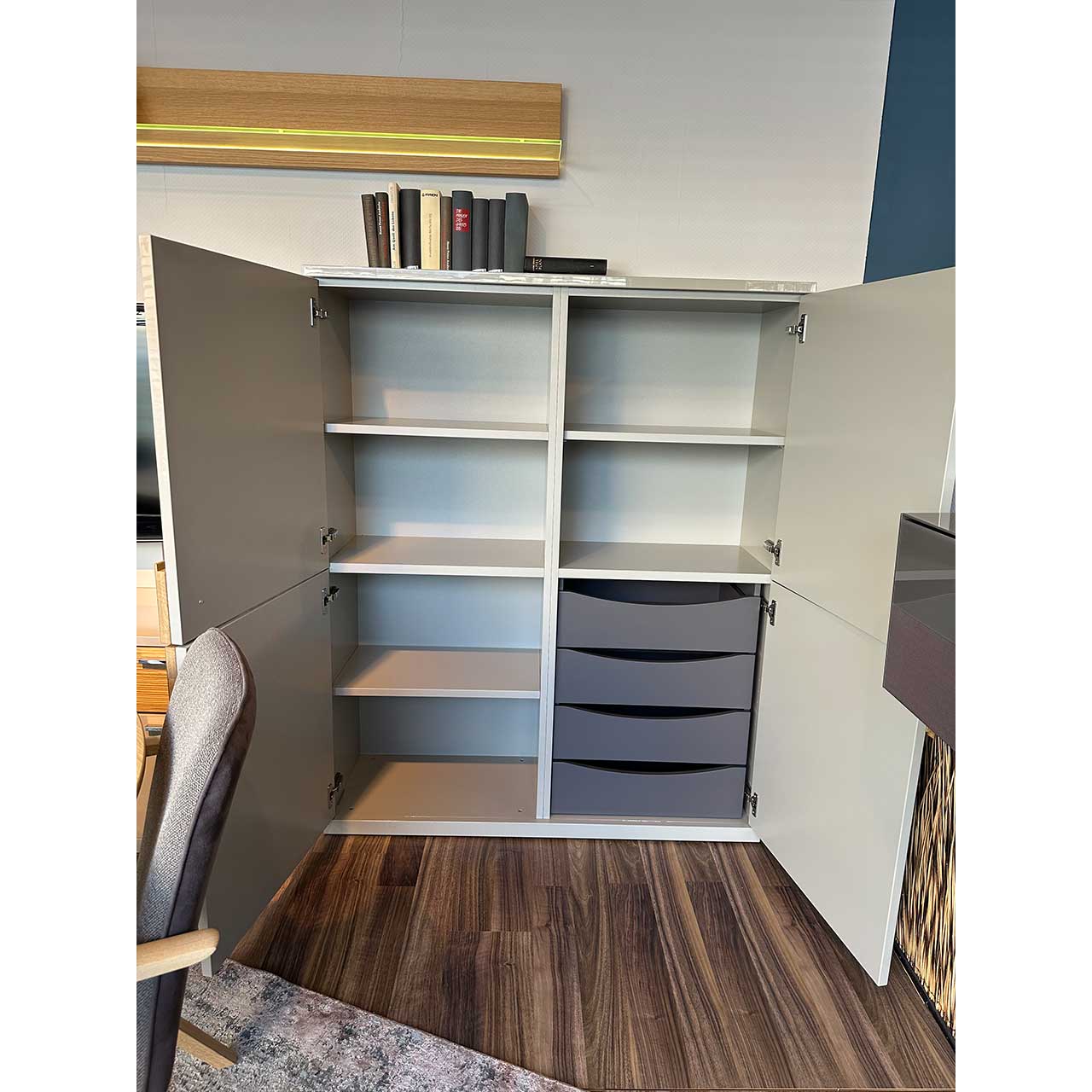 Das geöffnete Highboard zeigt links vier Fächer und rechts oben zwei Fächer. In dem Viertel rechts unten sind vier graue Innenschubladen.