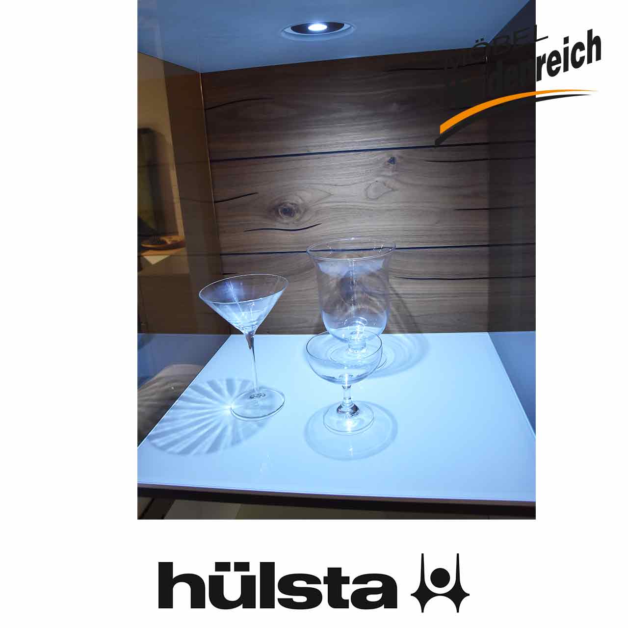 Hülsta Gentis - Vitrinenkombination Detail Glasausschnitt Detailaufnahme der Rückwand. Einzelne Holzbretter mit Maserung sichtbar, oben die Beleuchtungs-Spots.