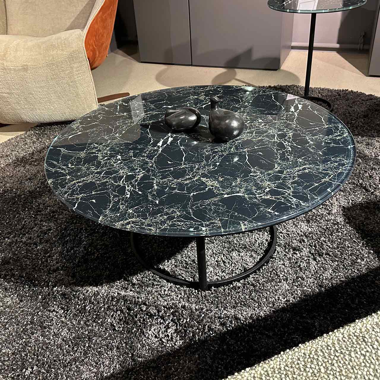 Couchtisch mit Glasplatte im Marmordruck auf einem ringförmigen schwarzen Gestell