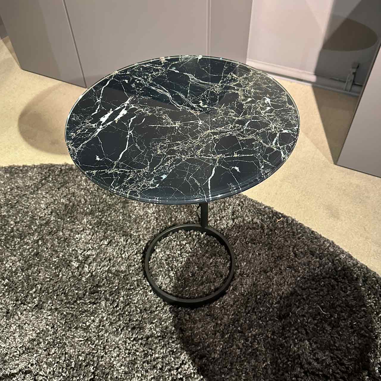 Beistelltisch mit im Marmorlook bedruckter Glasplatte auf schwarzem Ringgestell
