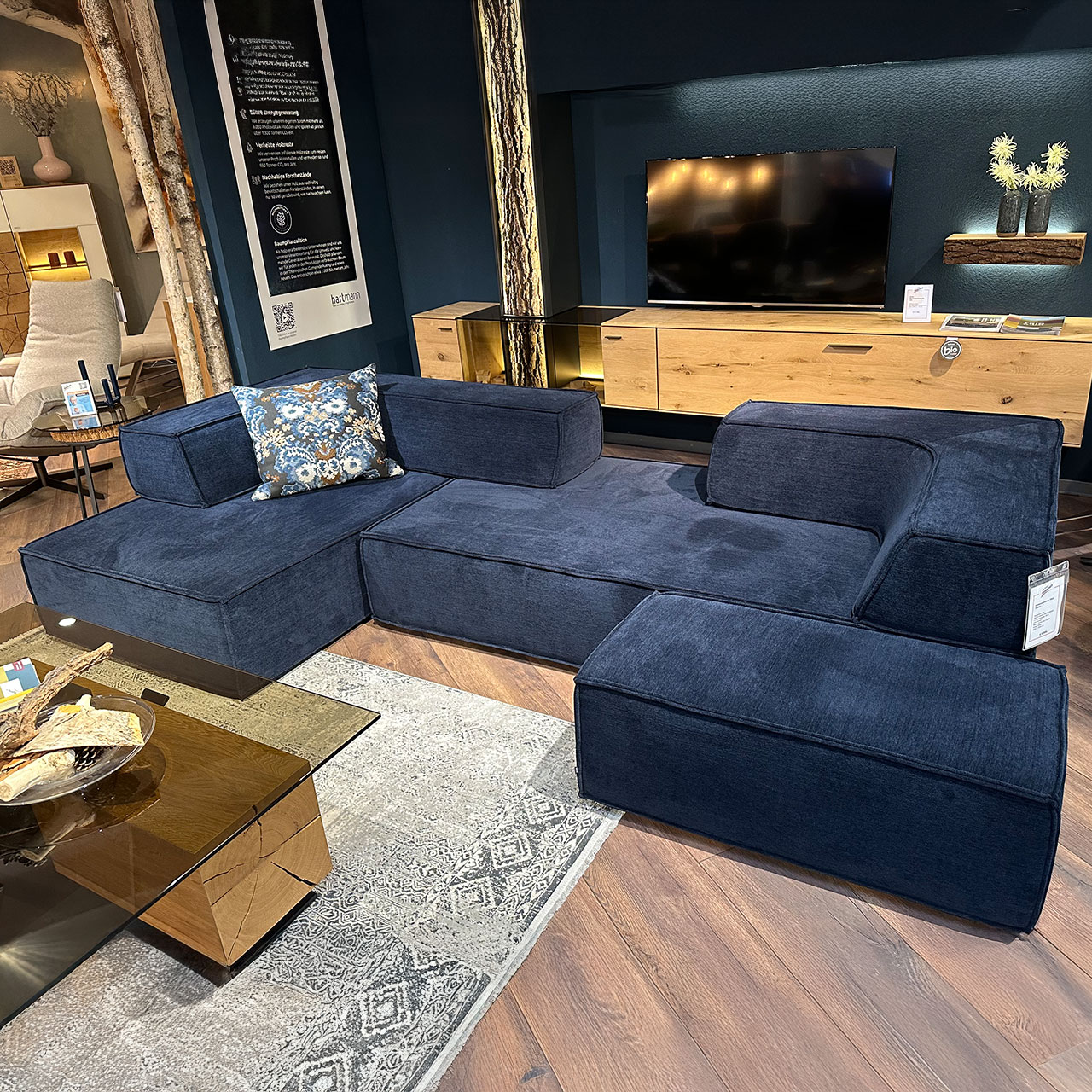 Polsterecke bestehend aus drei Sitzelementen und zwei Rückenteilen aus veloursartigem blauem Stoff