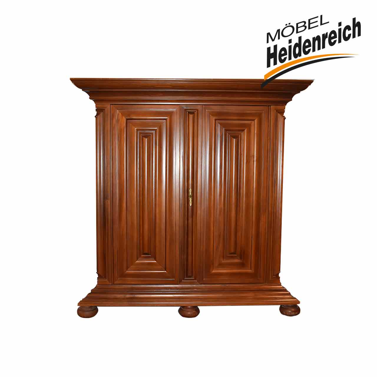 Barockschrank in dunklem Holz auf runden Füßen. Herausragender stufenförmiger Kranz oben, zwei Kassettentüren.
