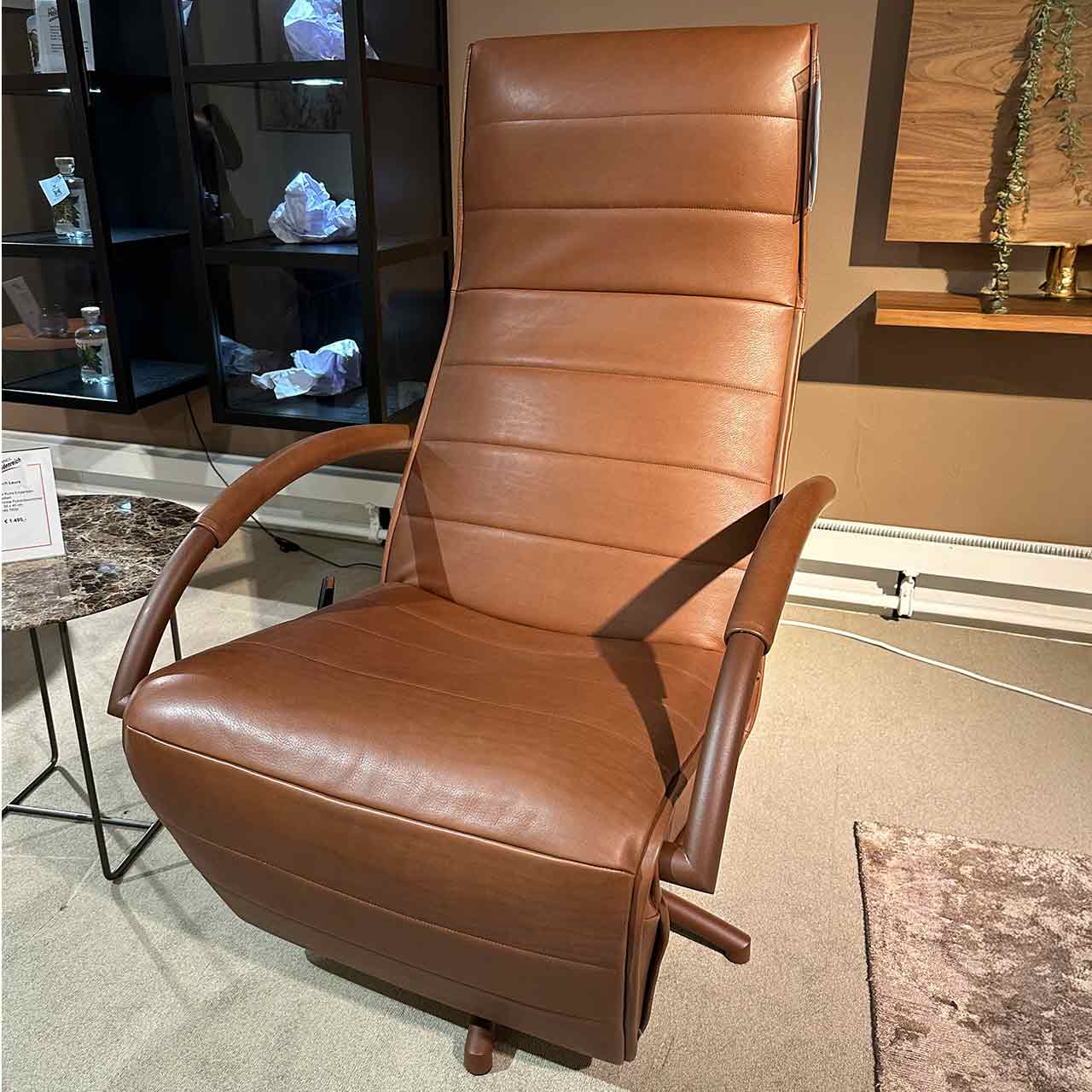 Brauner Fernsehsessel mit filigranen Armlehnen und Ziersteppung quer über der Lehne. Brauner Sternfuß.