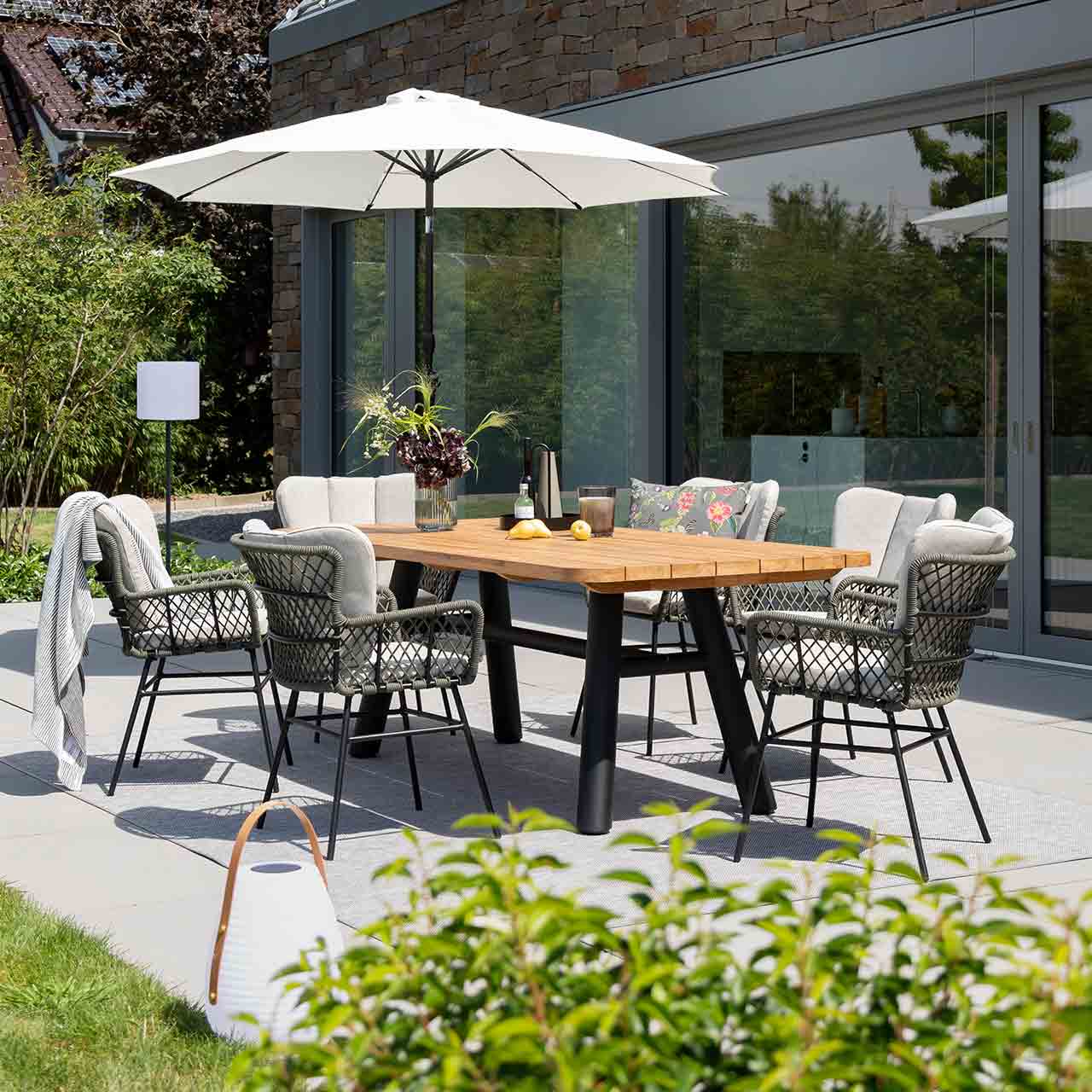 Teakholztisch SABA und der geflecht Stuhl Bennett Gartenesstisch Gruppe mit dem modernen rechteckigen Teakholztisch SABA mit swarzen modernen Untergestell, passend dazu der geflecht Stuhl Bennett inklusive Sitzkissen